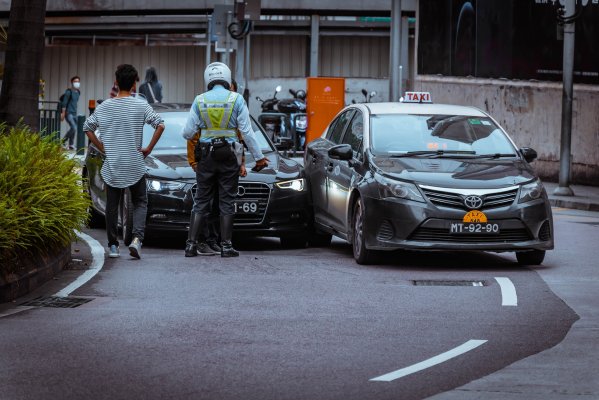 people looking at a car accident scene with police present